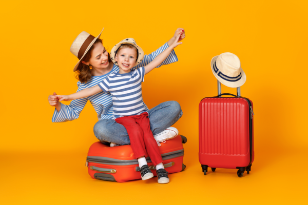Mama mit Kind und Koffer freudig