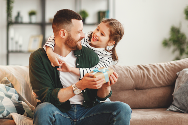 Tochter überreicht Vater Geschenk
