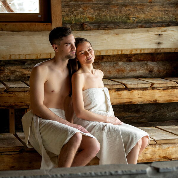Paar sitzt glücklich in der Sauna.